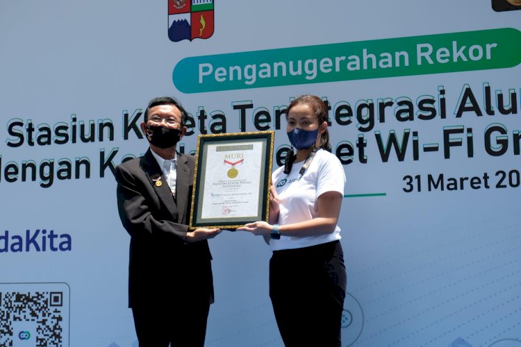 Direktur Operasional MURI Jusuf Ngadri menyerahkan piagam Rekor MURI kepada Direktur Pengembangan Bisnis Surge Martha Rebecca di Stasiun Bogor.(Ist/rmolsumsel.id)