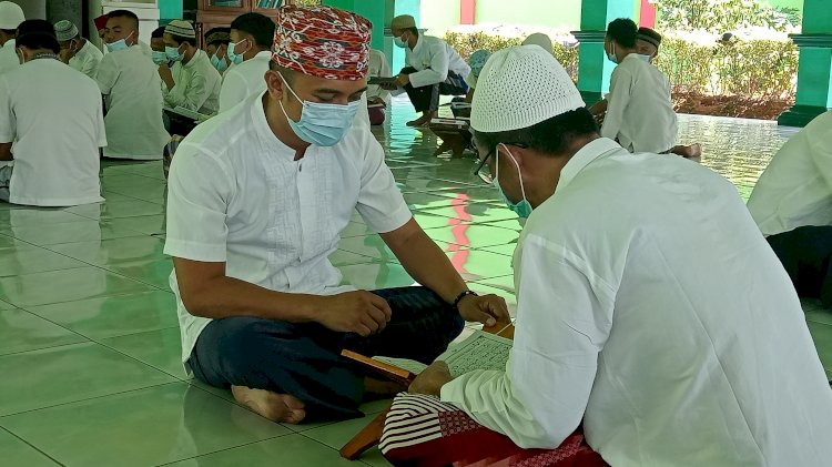 Dimas Adian Guta (38) sedang mengajari warga binaan lainnya membaca Al-Quran. (Noviansyah/Rmolsumsel.id). 