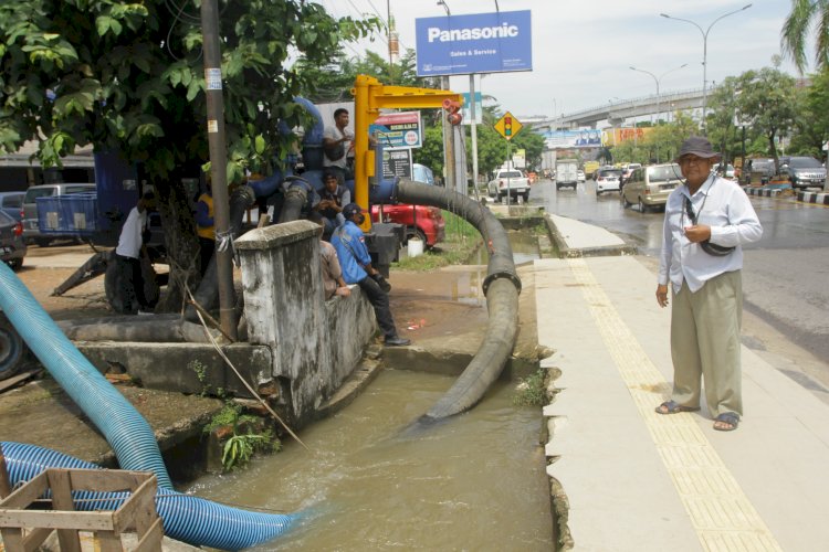 Petugas menggunakan pompa air untuk menyedot genangan air di Simpang Polda Palembang. (Humaidy Aditya Kenedy/Rmolsumsel.id). 