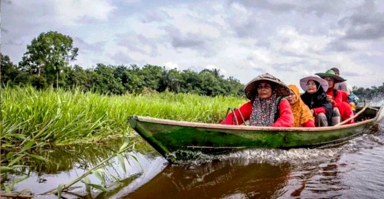 Masyarakat melintas di anak sungai yang masuk Kesatuan Hidrologis Gambut (KHG) di Kabupaten OKI. (Diskominfo OKI/rmolsumsel.id)