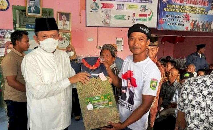 Bupati OKU Timur Lanosin menyerahkan bantuan pakaian adat kepada tokoh adat di Desa Bantan dan Bantan Pelita.(Diskominfo OKU Timur/rmolsumsel.id)