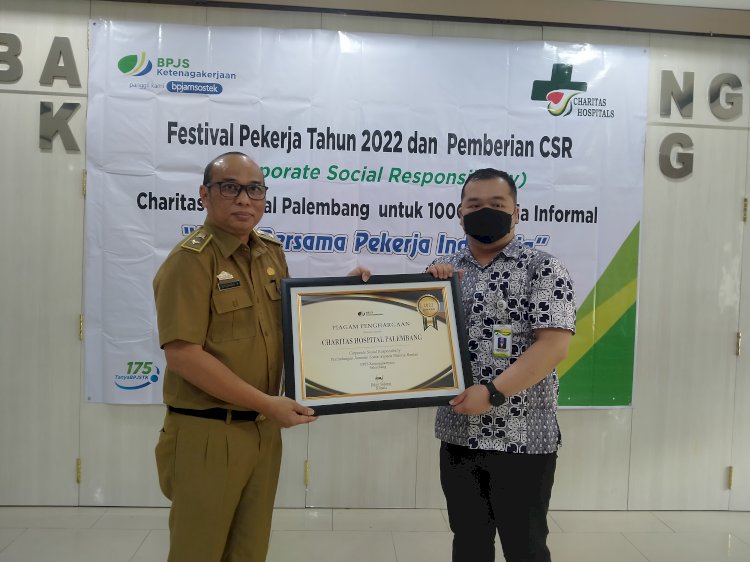 Kabid Perencanaan Eksosbud Bappeda Litbang Palembang, Syuhada memberikan pelakat kepada perwakilan RS Charitas Palembang. (Humaidy Aditya Kenedy/Rmolsumsel.id). 