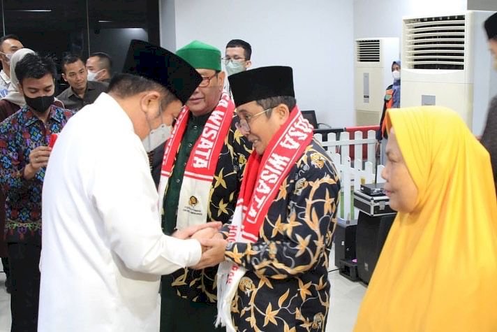 Gubernur Sumsel Herman Deru memasangkan syal kepada jemaah umrah yang diberangkatkan ke tanah suci oleh Holiday Angkasa Wisata, Kamis (26/5). (Humas Provinsi Sumsel/rmolsumsel.id)