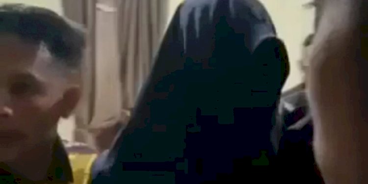 AKP ZA menutupi wajahnya saat terpergok warga berada di HY istri rekan kerjanya/Ist