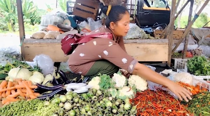 Salah seorang pedagang sayuran tengah menjajakan barang dagangannya. (ist/rmolsumsel.id)