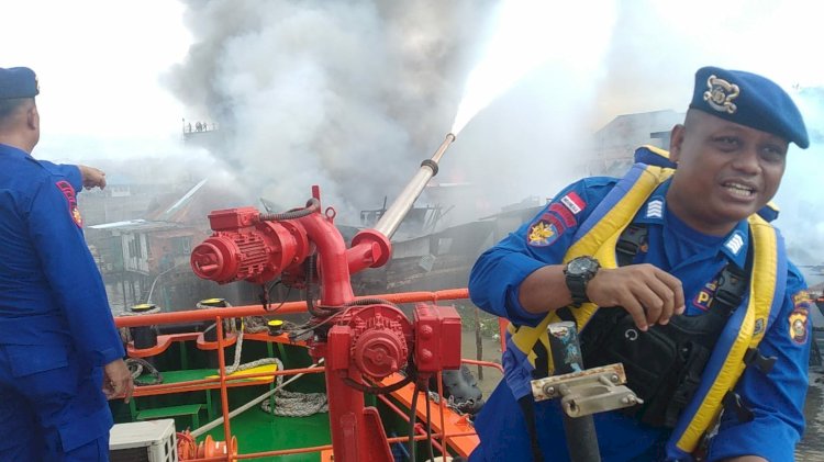 Petugas berjibaku memadamkan api yang terjadi di pemukiman pesisir Sungai Musi Palembang/Foto:Amizon