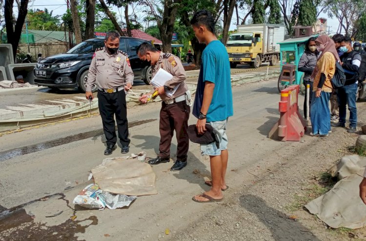 Polisi saat melakukan olah TKP di lokasi pengendara motor yang terlindas truk. (ist/Rmolsumsel.id)