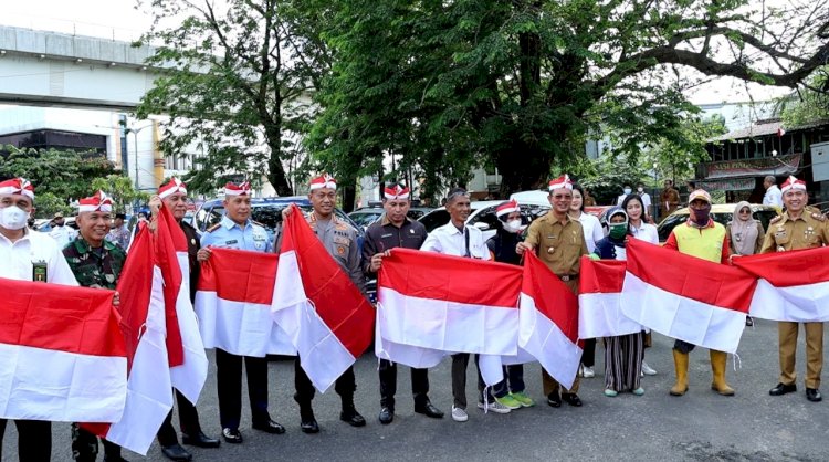 Forkopimda Kota Palembang membagikan bendera kepada masyarakat. (Humaidy Aditya Kenedy/rmolsumsel.id). 