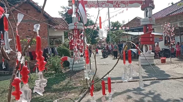 Warga Desa Penanggiran memasang hiasan berwarna merah putih dsri plastik es untuk meriahkan HUT RI ke-77. (Novian ayah/Rmolsumsel.id). 