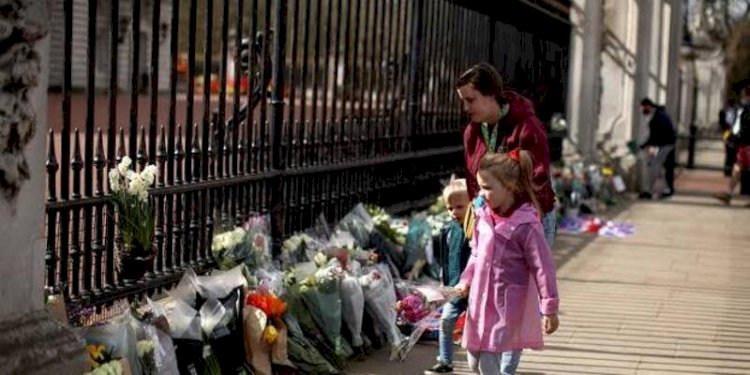 Warga Inggris sedang menaruh karangan bunga di gerbang hitam kerajaan setelah kematian Ratu Elizabeth II/Net
