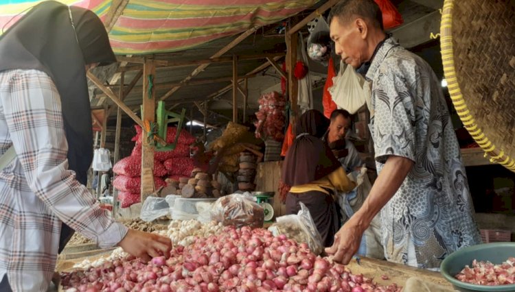 Bohirin pedagang bawang di Pasar Inpres tengah melayani pembeli.(foto Istimewa)