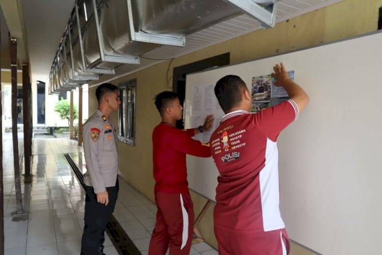 Anggota Polres Muba menempelkan pemberitahuan pembukaan pendaftaran Tamtama Polri/ist