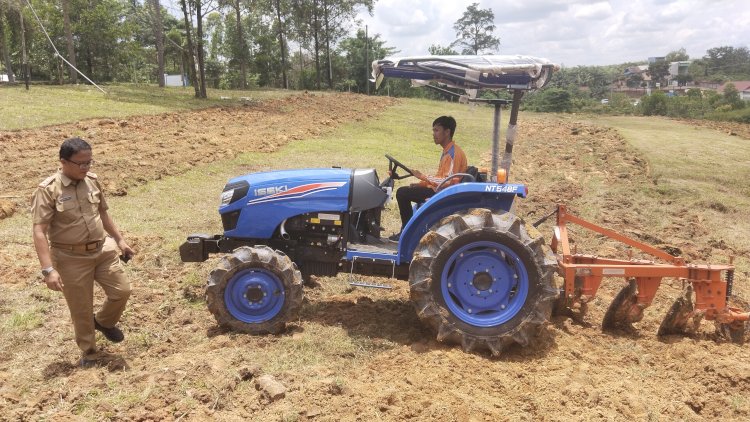 Traktor dari Dinas Pertanian PALI tengah menggarap lahan kosong di dekat Kantor Pemkab PALI untuk ditanam ubi kayu. (ist/rmolsumsel.id)