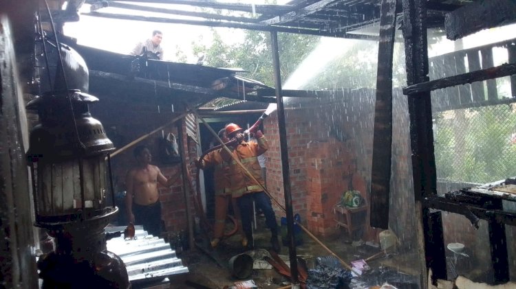 Petugas tengah memadamkan sisa api kebakaran dari gudang.(foto Istimewa)