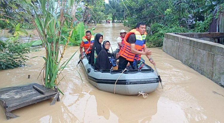 Sejumlah warga di Langsa menaiki perahu karet menuju lokasi pengungsian, setelah rumah mereka terendam banjir. Foto: BPBA.