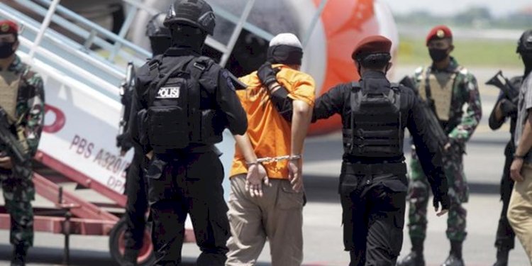 Personel Densus 88 tengah menggelandang tersangka terorisme/Net