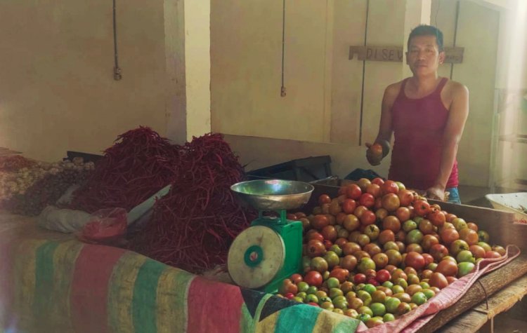 Tampak Edi (34) salah satu pedagang sayur di pasar Inpres Muara Enim yang menjelaskan saat ini harga sayur mayur mengalami kenaikan/Noviansyah.