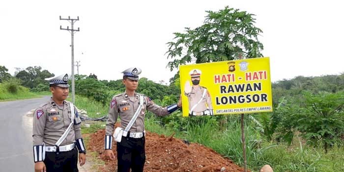 Satlantas Polres Empat Lawang memasang spanduk peringatan rawan longsor dan kecelakaan, Senin (28/11). (Salim/RmolSumsel.id)