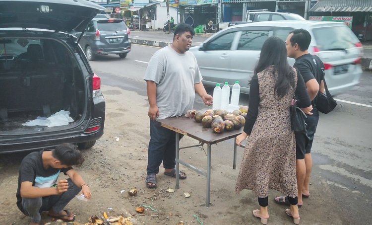 Romi (26) pedagang buah lontar yang berjualan di sekitaran Jalan Demang Lebar Daun Kota Palembang, Rabu (7/12/2022)/Adam Rachman. 