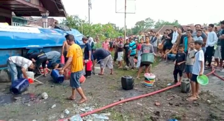 Tampak masyarakat memperebutkan minyak yang tertumpah akibat truk tangki terbalik di  jalan lintas Muara Enim-Prabumulih Desa Teluk Lubuk, Kecamatan Belimbing, Kabupaten Muara Enim, Sumatera Selatan, pada Minggu (1/1). (dok. Satlantas Polres Muara Enim)