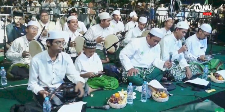 Para nahdliyin yang hadir di acara puncak resepsi 1 abad NU di Gelora Delta Sidoarja sedang bersholawat berjamaah/Repro