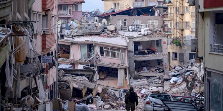 Seorang tentara Turki berjalan di antara gedung-gedung yang hancur akibat gempa bumi di Hatay, Turki/Net