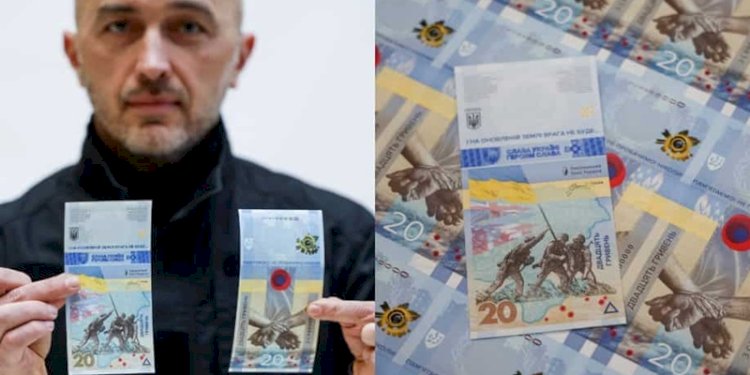 Gubernur Bank Nasional Ukraina Andriy Pyshnyi memegang uang kertas yang didedikasikan untuk peringatan pertama invasi Rusia di Ukraina/Foto: Reuters