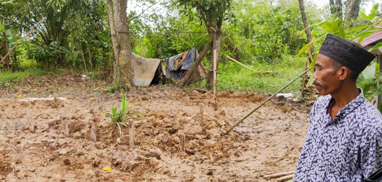 Salah satu keluarga korban, Fendi (53) menunjukan lokasi pemakaman lima korban kecelakaan maut di Gelumbang, Muara Enim pada Senin (27/2) kemarin. (Adamrachman/Rmolsumsel.id)