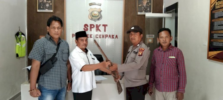 Makmur Jakpat Sekdes Gunung Batu, Kecamatan Semendawai Barat saat menyerahkan senpi ke Polsek Cempaka/ist.