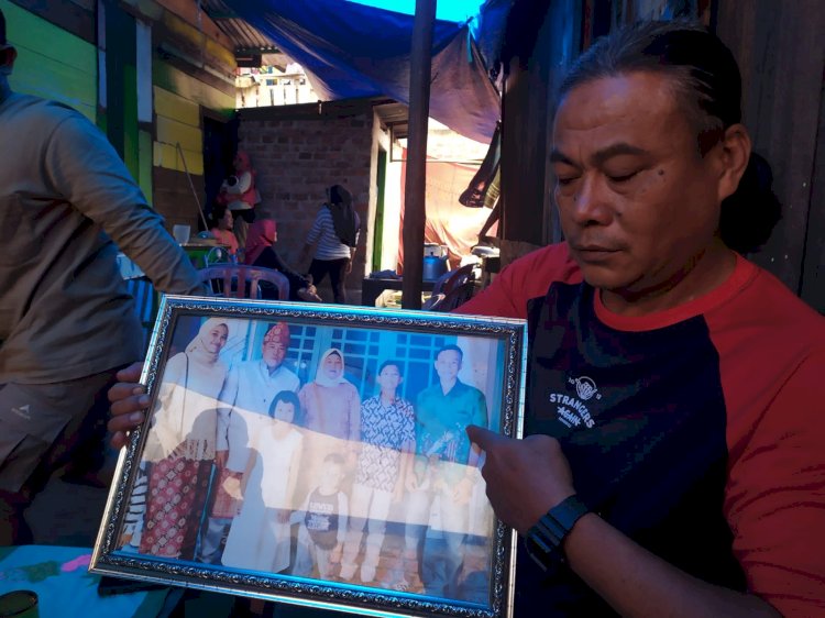 Ayah korban, Ikhsan (48) saat menunjukan foto keluarganya ketika dibincangi sejumlah awak media di rumah duka, Kamis (2/3/2023). (Adam Rachman/Rmolsumsel.id). 