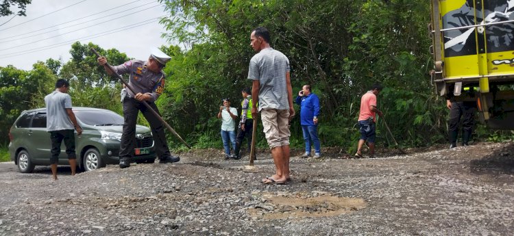 Anggota Satlantas Polres OKU dan warga memperbaiki badan Jalinteng dalam Kota Baturaja yang rusak, Rabu (8/3). (Amizon/RmolSumsel).