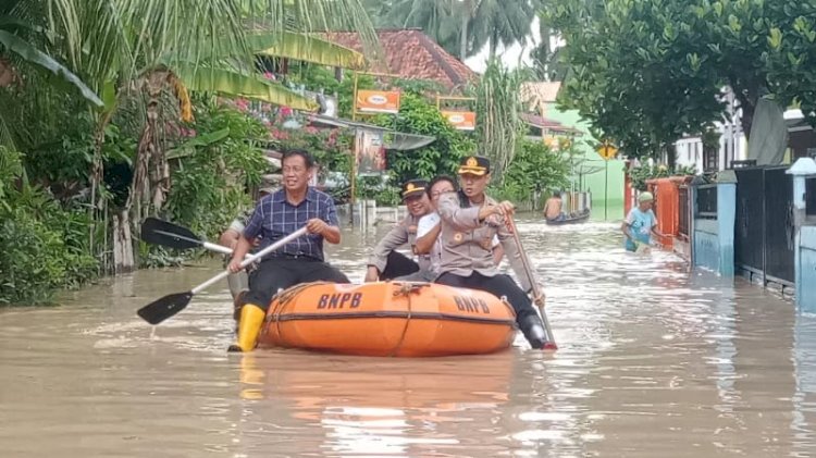 Petugas menyisir lokasi banjir dengan menggunakan perahu karet/Foto:Noviansyah