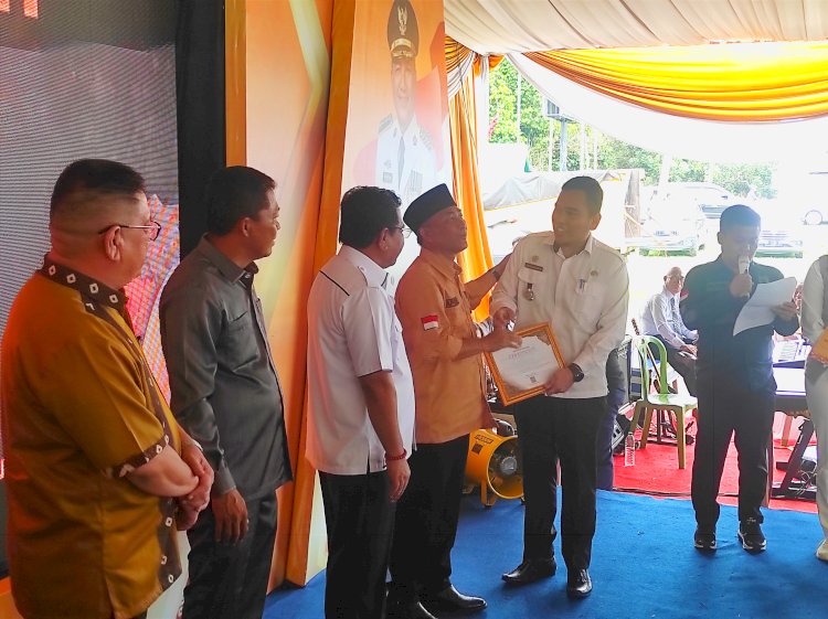 Plt Muba Muba Apriyadi menyerahkan penghargaan kepada kecamatan yang berhasil melakukan realisasi PBB terbaik sepanjang 2022. (Amarullah Diansyah/Rmolsumsel.id).