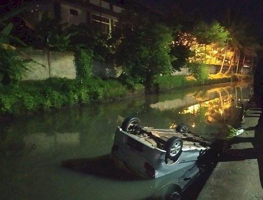 Sebuah mobil terperosok hingga masuk ke sungai Sahang di belakang gedung Politeknik Sriwijaya, Palembang, Selasa (18/4) petang. (ist/rmolsumsel.id)