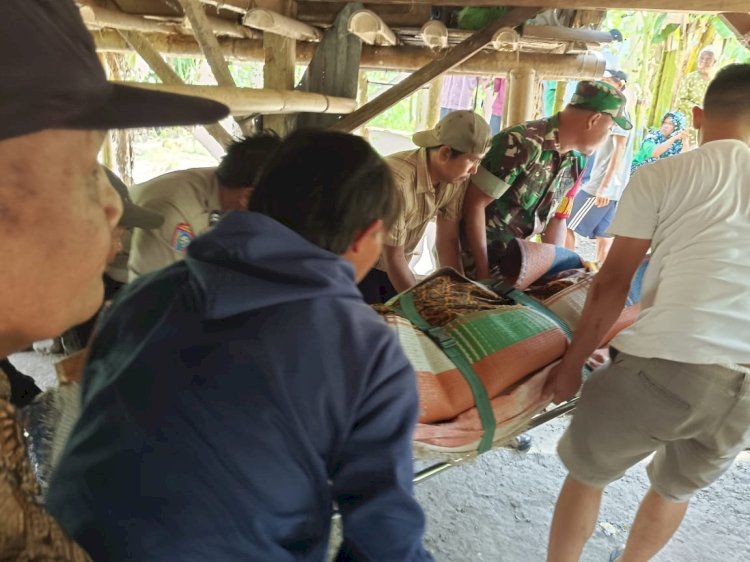 Petugas melakukan evakuasi terhadap Kader (70) yang tewas dibunuh anak kandungnya sendiri. (Salim/RmolSumsel.id)