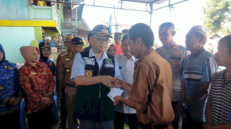 Bupati memberikan bantuan kepada warga yang diterima secara simbolis oleh Pj Kepala Desa Lampar Baru, Amrullah/ist