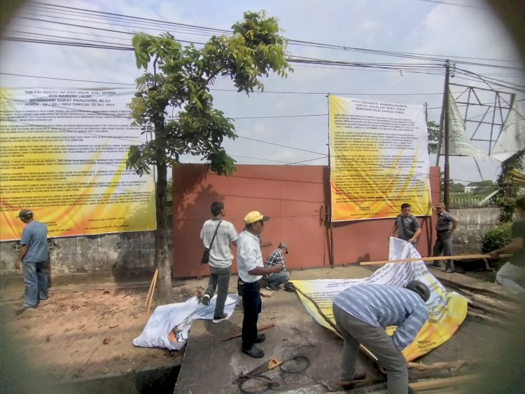 Puluhan warga yang mengaku ahli waris dari Kgs Nanung (alm) melakukan aksi pemasangan spanduk di lahan yang bersengketa di Jalan Kol H Burlian, Kelurahan Karya Baru, Kecamatan Alang-Alang Lebar (AAL) KM 8 Palembang,  Minggu (3/6) pagi. (Dudi/RmolSumsel.id)
