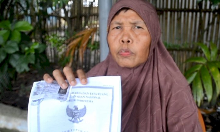 Yuliana (55) perlihatkan surat hak milik atas lahan kebun miliknya yang diduga tercemar limbah PT Energi Tanjung Tiga (ETT)/Foto:Noviansyah