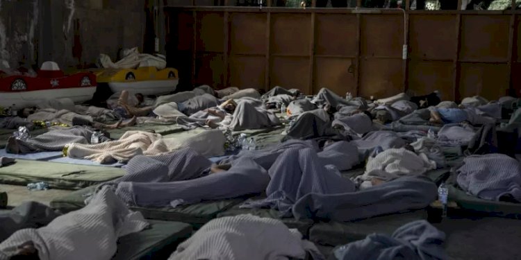 Para penyintas kapal karam tidur di sebuah gudang di pelabuhan di kota Kalamata, Yunani pada Rabu, 14 Juni 2023/Washington Post