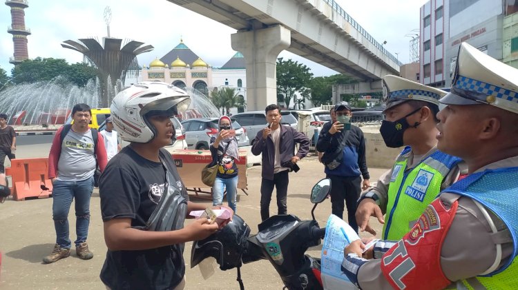 Personel Satlantas Polrestabes Palembang saat menindak pengendara motor yang melawan arus . (Fauzi/RmolSumsel.id)