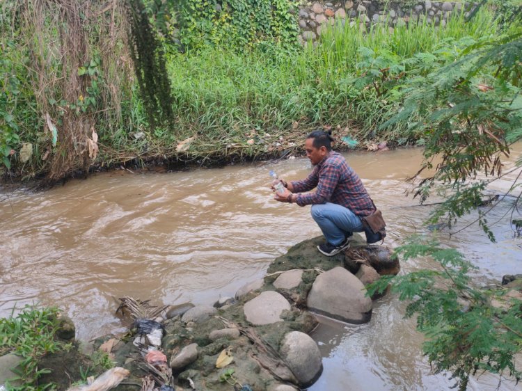 Aktivis Kawali Sumsel memeriksa kualitas air di sungai kelekar yang tercemar minyak akibat bocornya pipa Pertamina. (ist/RmolSumsel.id)