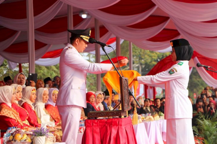 Plt Bupati Muara Enim, Ahmad Usmarwi Kaffah berikan bendera merah putih kepada petugas pembawa baki.(Noviansyah/RMolSumsel.id)
