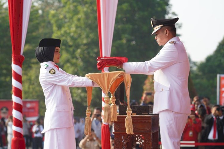 BUpati OKU Timur H Lanosin Hamzah menyerahkan bendera merah putih kepada Pembawa Baki/ist