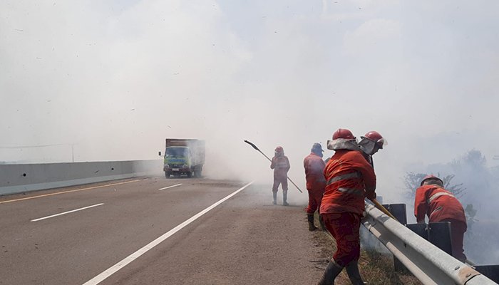 Petugas Manggala Agni saat berjuang melakukan upaya pemadaman karhutla di lahan dekat jalan tol Kayuagung-Palembang. 