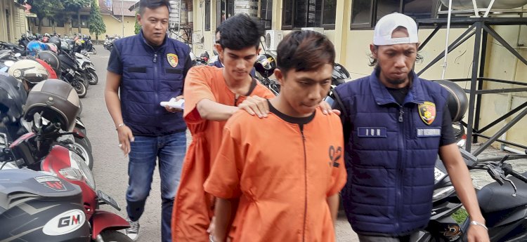 Bobi Setiawan oknum honorer di Kementerian Perhubungan dan Reby Mulia saat digiring petugas menuju ruang pemeriksaan unit 4 Subdit III Jatanras Ditreskrimum Polda Sumsel /Foto:Fauzi
