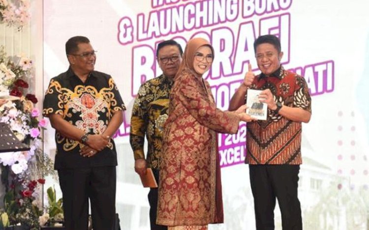Ketua DPRD Sumsel RA Anita Noeringhati saat menyerahkan buku biografinya berjudul Singa Betina Parlemen kepada Gubernur Sumsel, Herman Deru. (ist/rmolsumsel.id) 