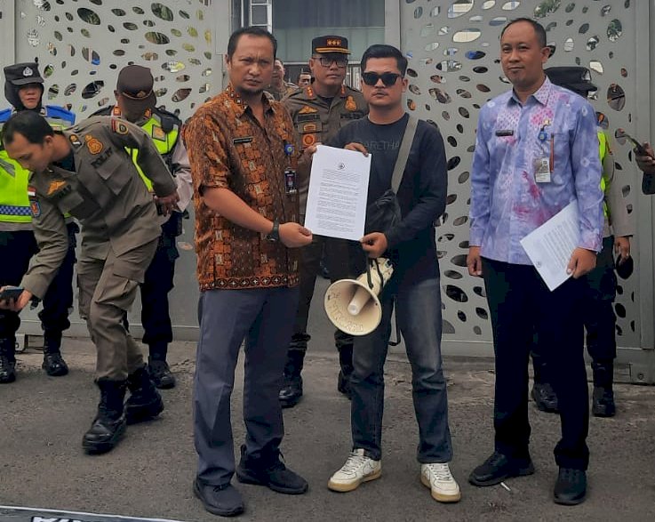 Perwakilan massa MMPPL memberikan berkas tuntutan kepada Kabid Gakkum Dinas LHP Sumsel, Yulkar Pramilus saat gelar aksi beberapa waktu lalu. (ist/rmolsumsel.id)