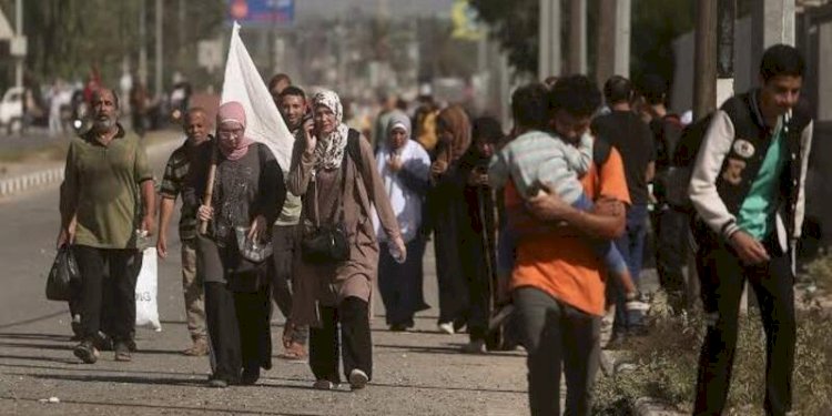 Seorang wanita membawa bendera putih bersama sekelompok warga Palestina yang melarikan diri dari Kota Gaza ke Jalur Gaza selatan di jalan Salah al-Din di Bureij, 8 November 2023/AP