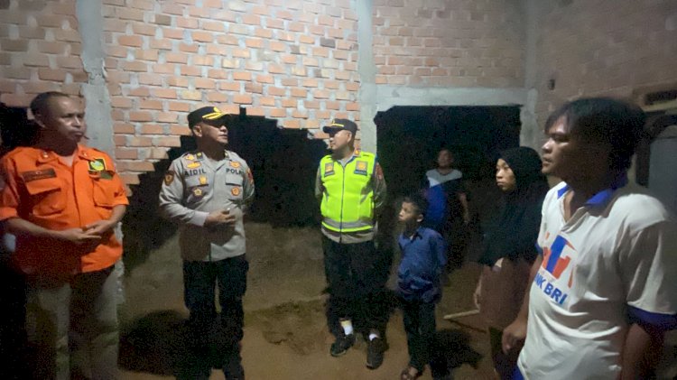 Kompol Aidil bersama Kapolsek memberikan bantuan kepada warga yang terkena musibah tanah longsor. (ist/RMOLSumsel.id)