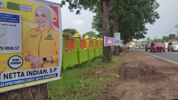 Pemasangan Alat Peraga Kampanye (APK) di Banyuasin, Sumatera Selatan dipasang di depan pohon pagar sekolah.(Arda Ismail/RMOLSumsel.id)